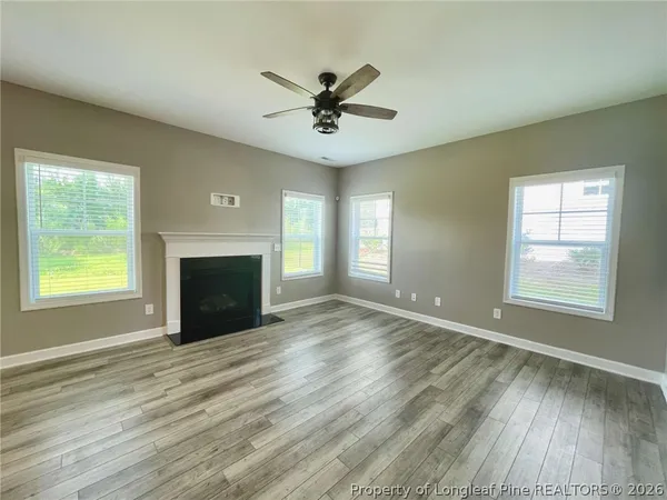 an empty room with windows and fireplace
