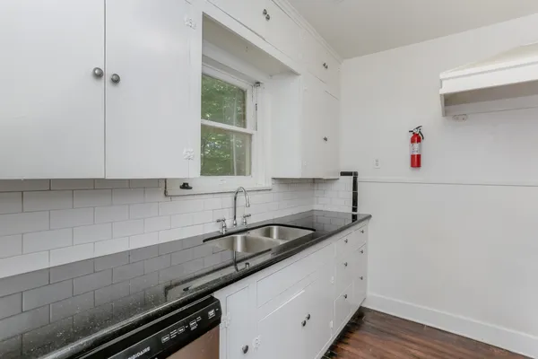 a kitchen with granite countertop a sink and cabinets