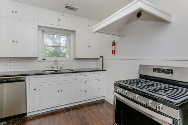 a kitchen with granite countertop cabinets and window