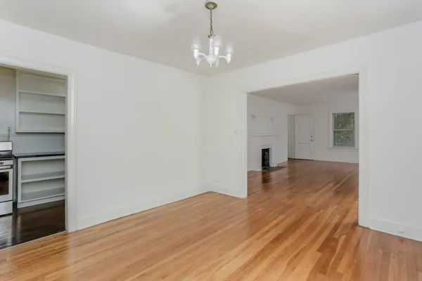 a view of empty room with wooden floor and fireplace
