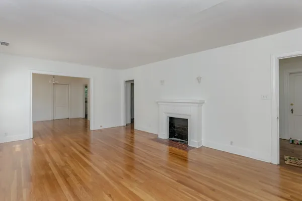 a view of empty room with wooden floor and fireplace