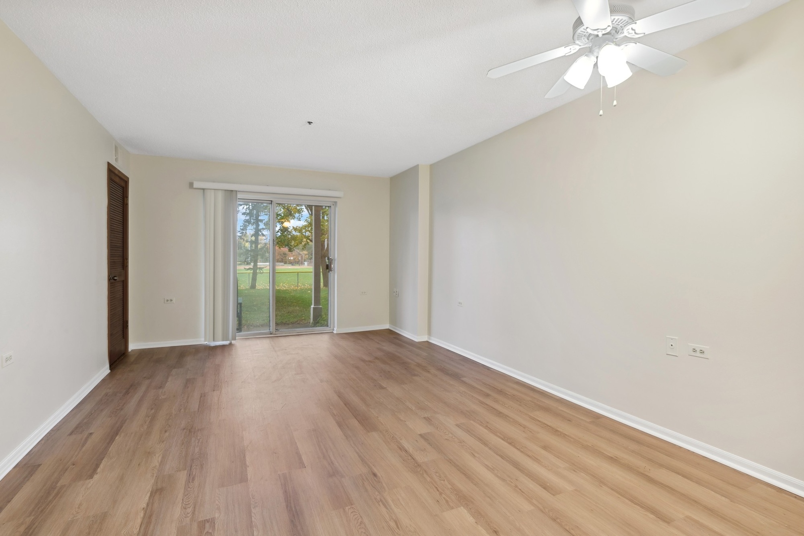 800 Ridge Road, Unit 103 Wilmette, IL 60091 - Photo 4 of 12 an empty room with wooden floor fan and windows