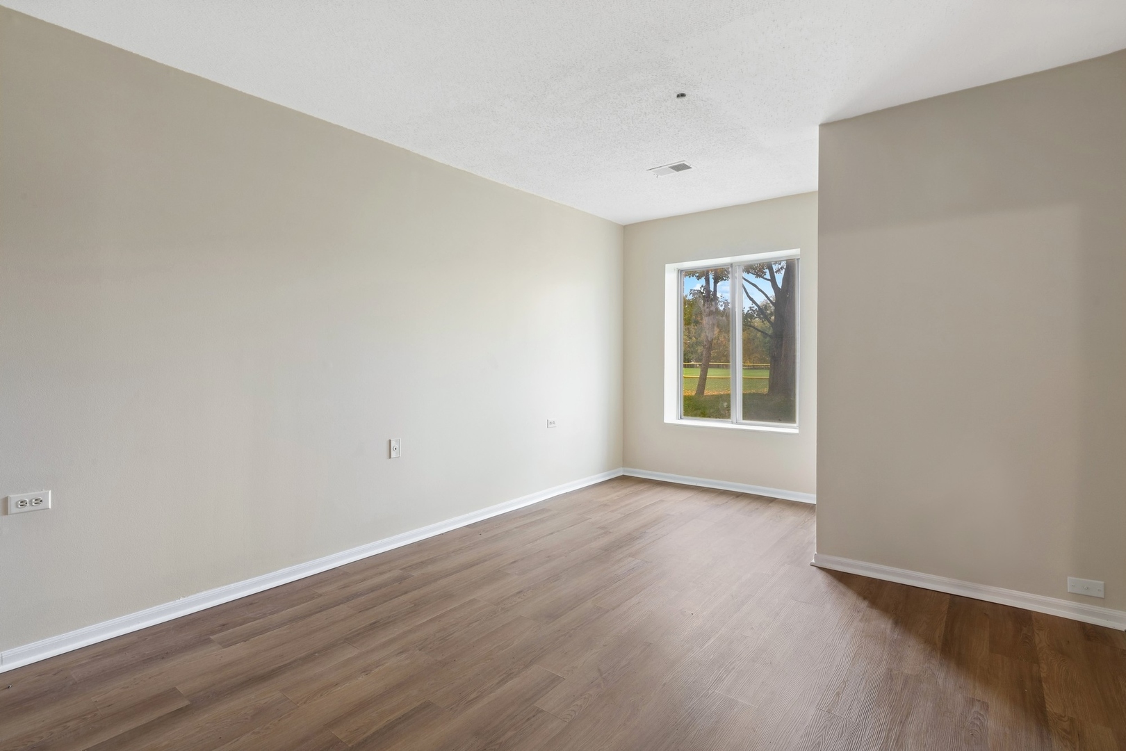 800 Ridge Road, Unit 103 Wilmette, IL 60091 - Photo 5 of 12 a view of an empty room with wooden floor and a window