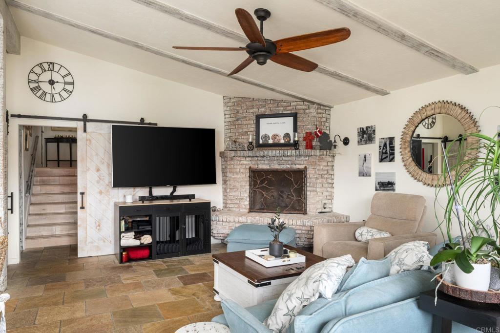 200 Neptune Avenue Encinitas, CA 92024 - Photo 29 of 33 a living room with furniture a flat screen tv and a fireplace