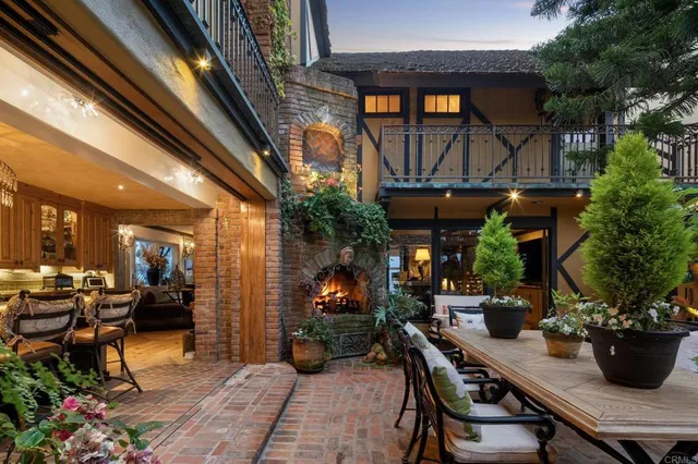 a view of a patio with table and chairs potted plants and floor to ceiling window and potted plants