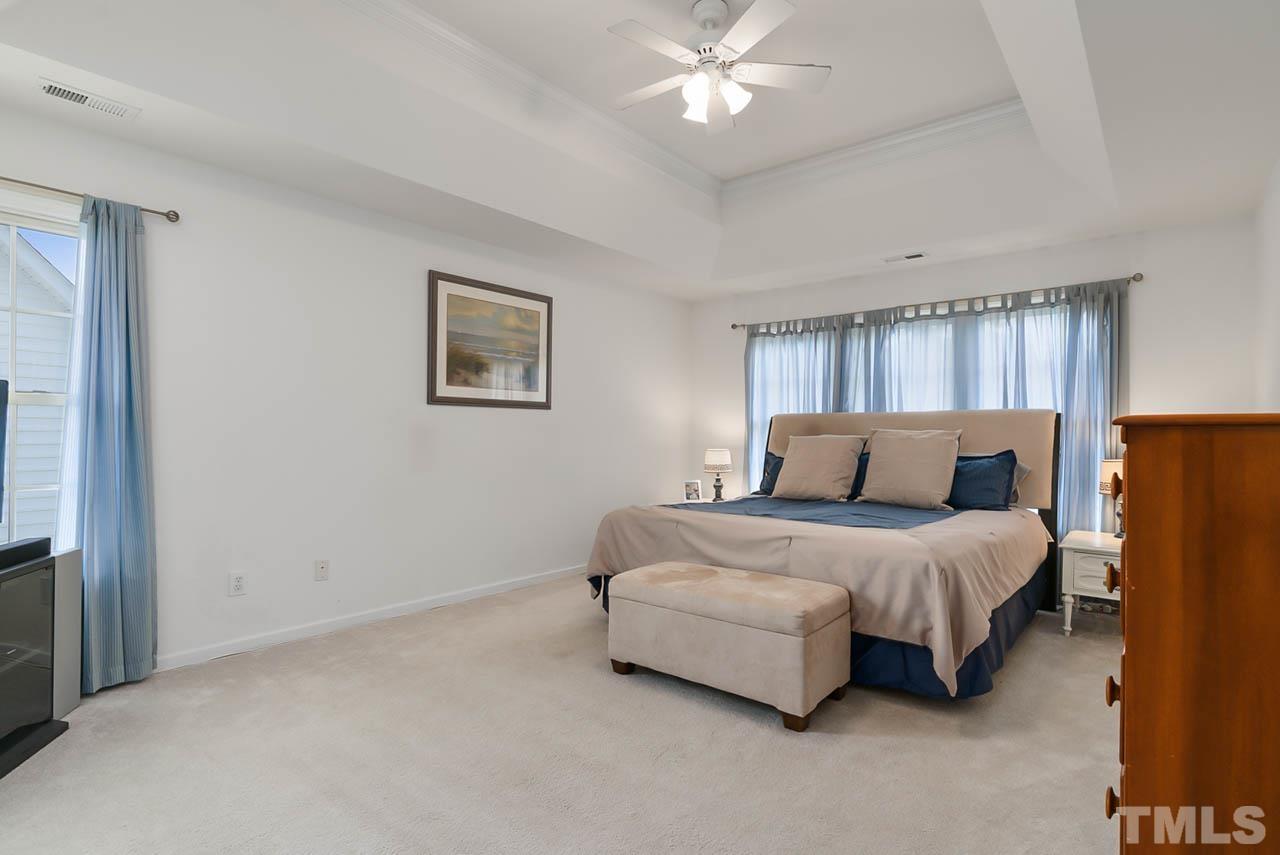 5906 Big Nance Drive Raleigh, NC 27616 - Photo 25 of 40 a spacious bedroom with a bed and a chandelier
