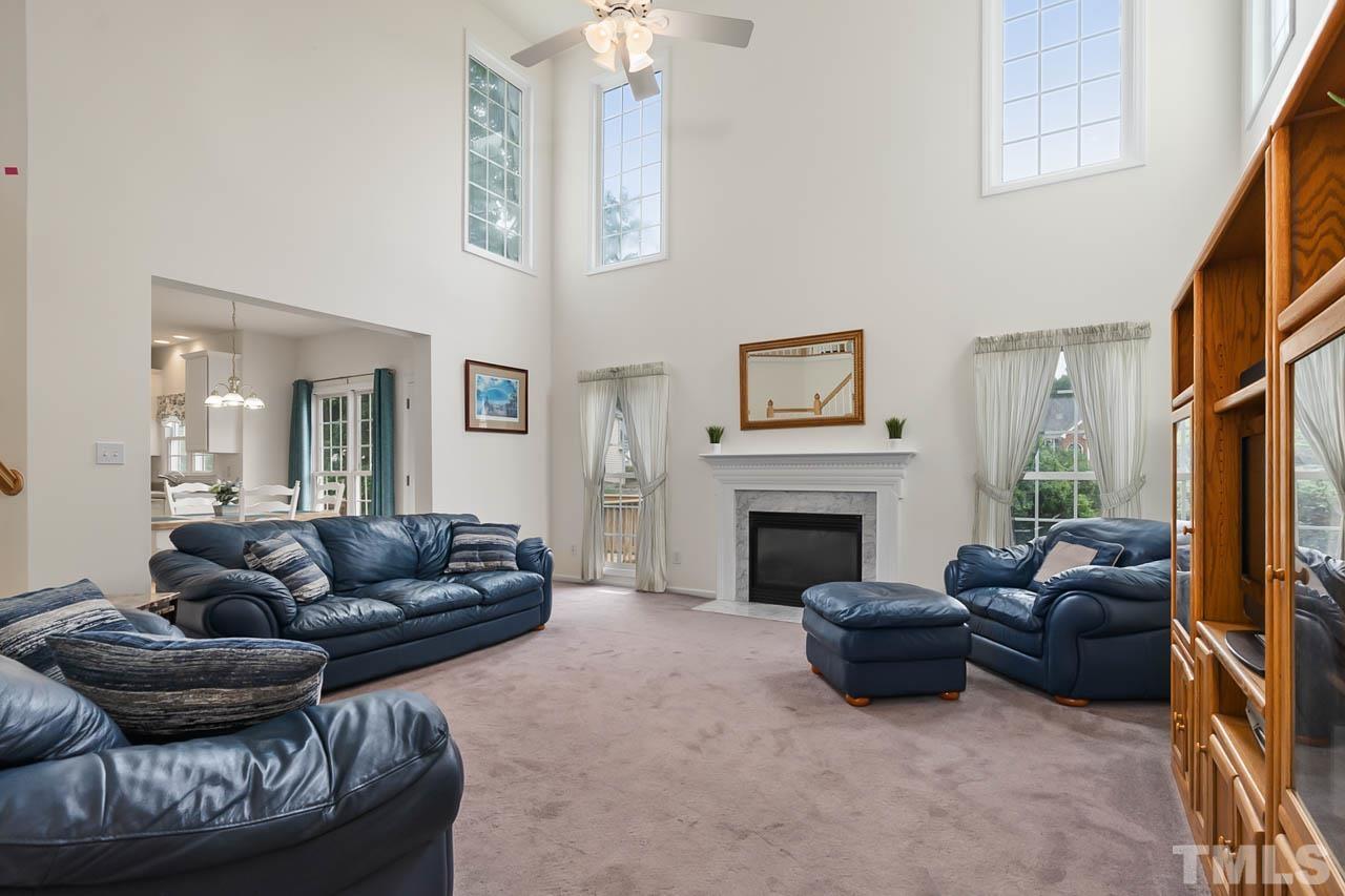 5906 Big Nance Drive Raleigh, NC 27616 - Photo 9 of 40 a living room with furniture a fireplace and a flat screen tv