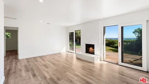 an empty room with wooden floor and fireplace