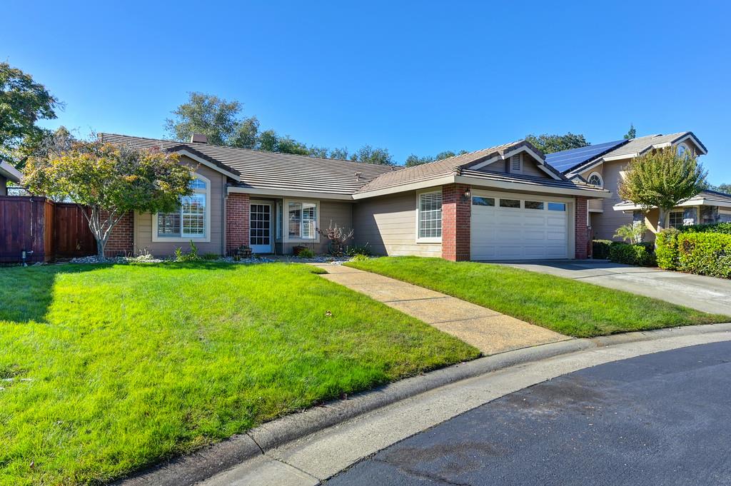a view of a house with a big yard plants and large trees