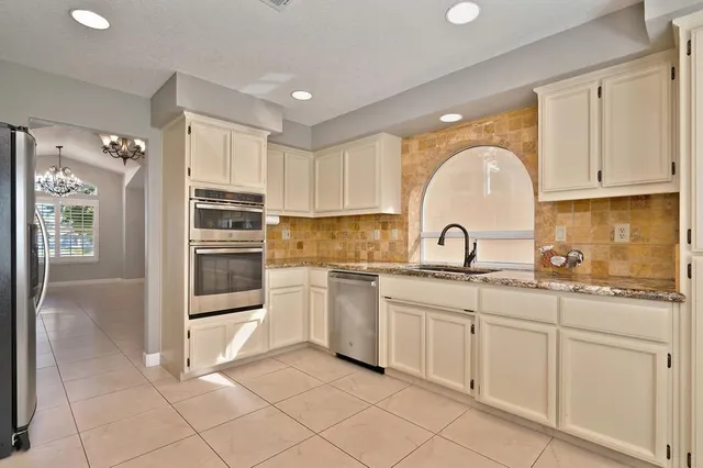 a kitchen with white cabinets and sink
