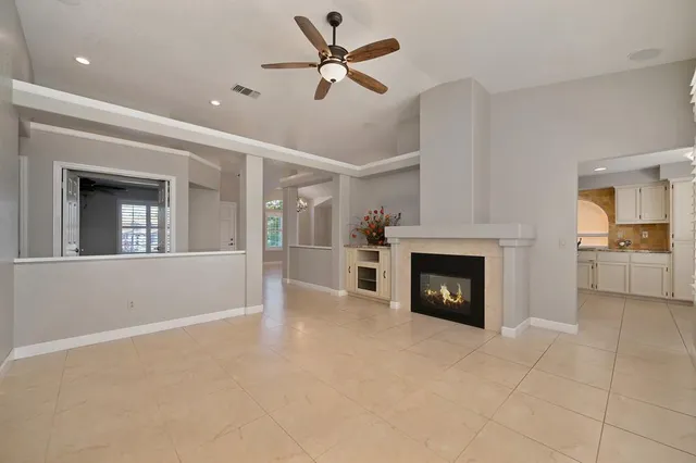 a view of a livingroom with a fireplace and a ceiling fan