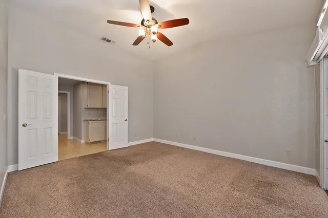 en empty room with closet and a ceiling fan