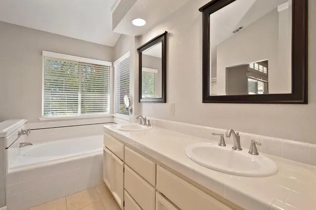 a bathroom with a bathtub sink and mirror