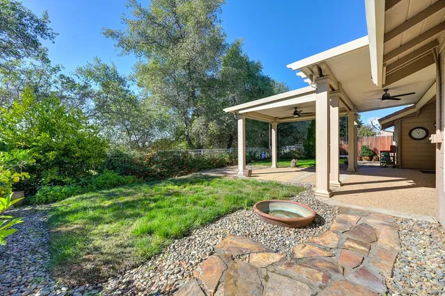 a view of a house with backyard and sitting area