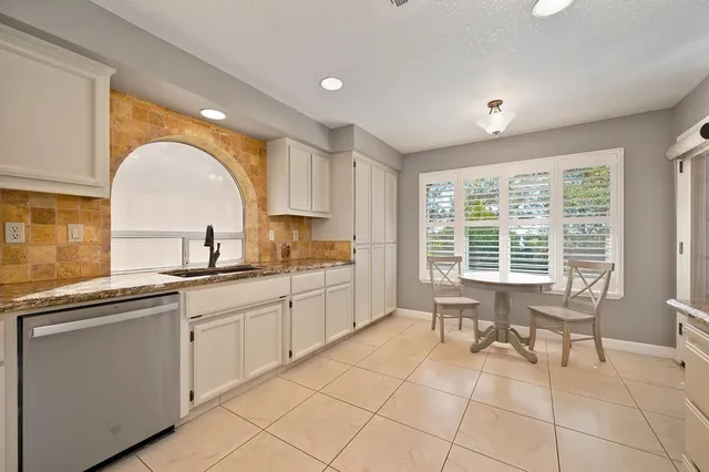a kitchen with a sink and white cabinets