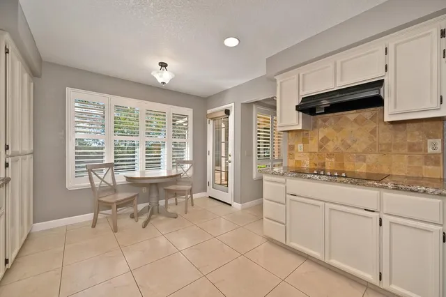 a kitchen with granite countertop a sink and white cabinets