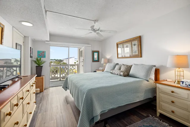 a large bedroom with bed and wooden floor