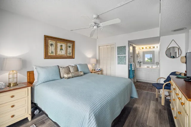 a spacious bedroom with a bed and wooden floor