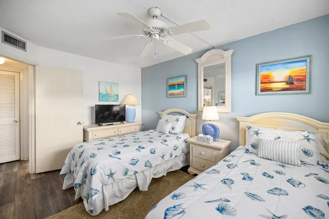 a bedroom with two beds and a chandelier