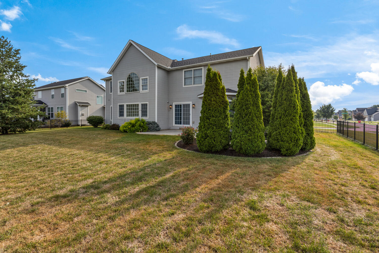 1621 English Oak Drive Champaign, IL 61822 - Photo 46 of 62 a view of a white house next to a yard with plants and a large tree