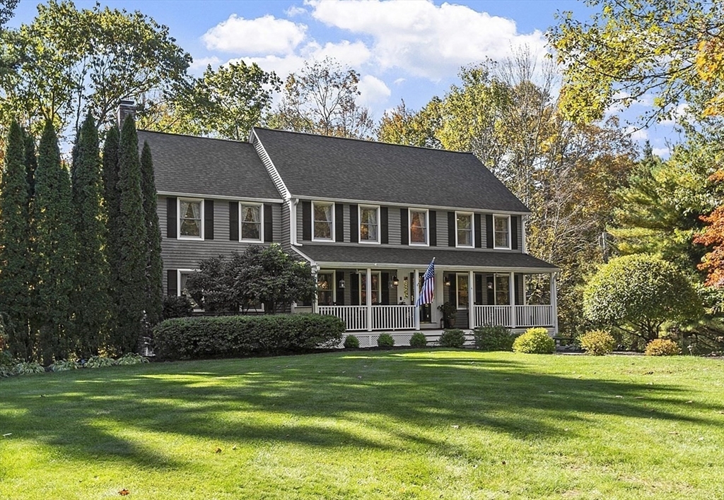a front view of a house with a garden and trees