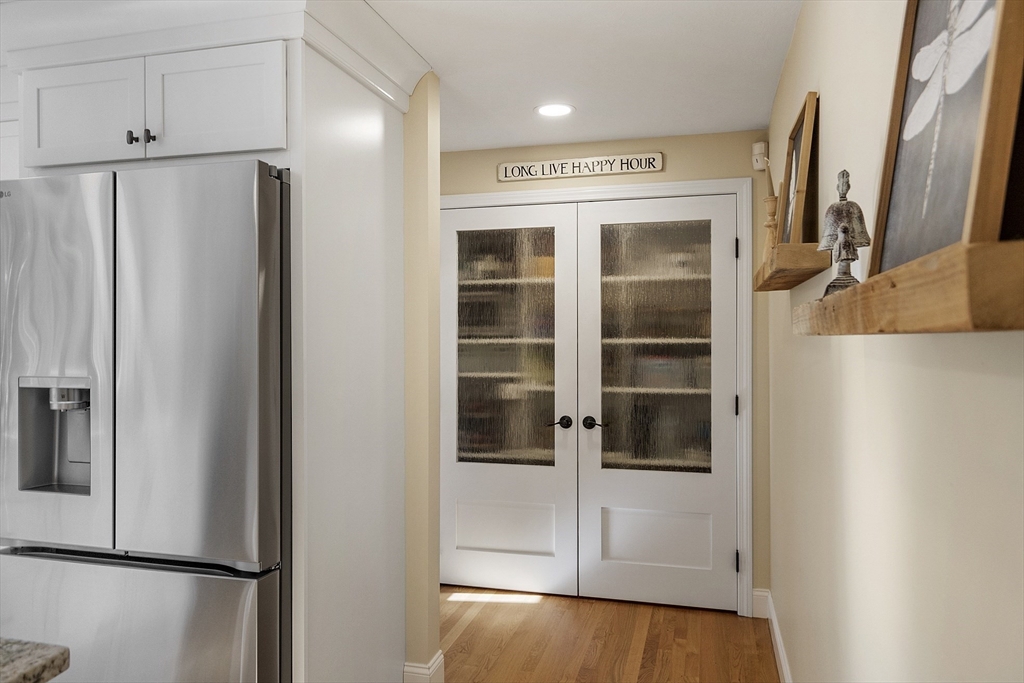 4 Celestial Way Pepperell, MA 01463 - Photo 13 of 41 a view of a refrigerator in kitchen and an empty room with wooden floor