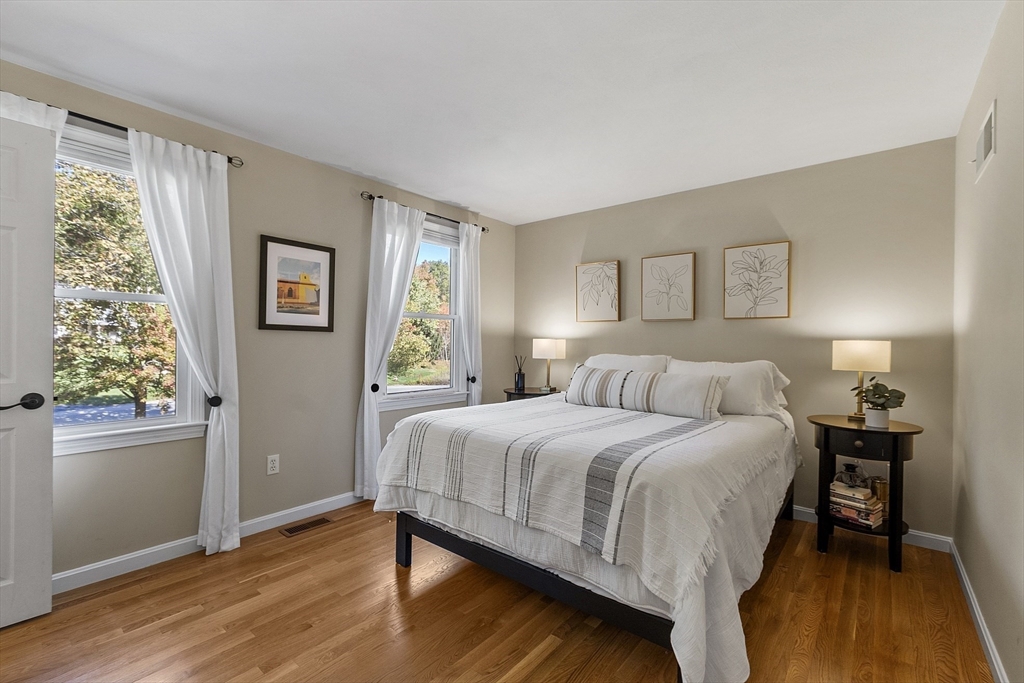 4 Celestial Way Pepperell, MA 01463 - Photo 30 of 41 a bedroom with a bed and wooden floor