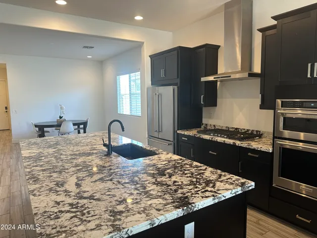 a kitchen with a refrigerator and a stove top oven