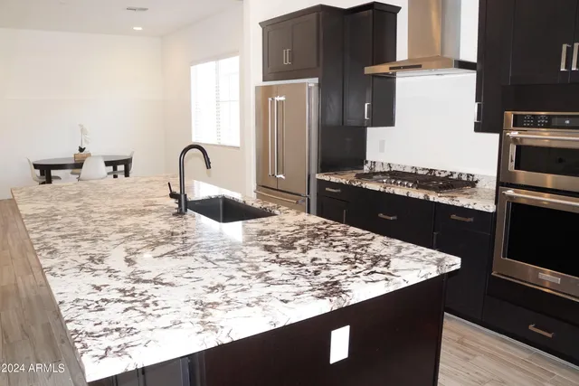 a kitchen with kitchen island stainless steel appliances a sink stove and refrigerator