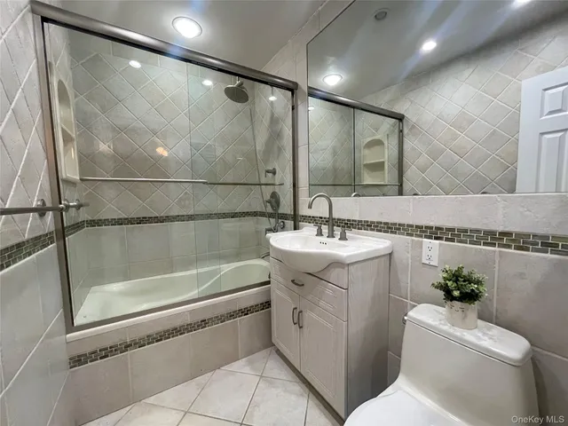 a bathroom with a granite countertop sink mirror toilet and bathtub