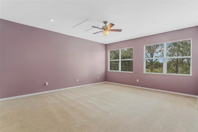 en empty room with a ceiling fan and a rug