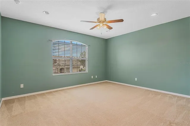 an empty room with closet and a chandelier fan