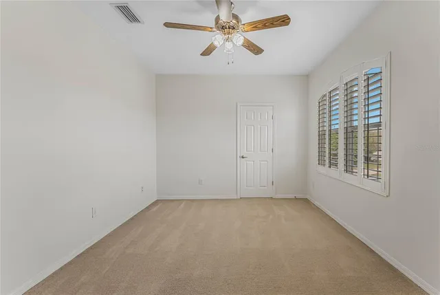 an empty room with a ceiling fan and fan