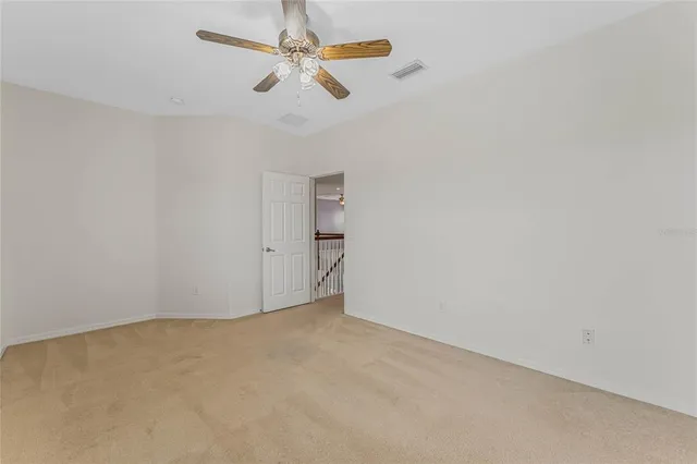 an empty room with a ceiling fan and a window