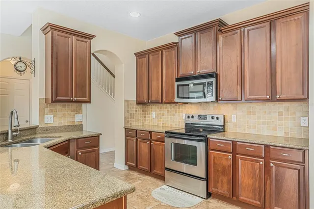 a bathroom with a granite countertop sink a toilet and mirror