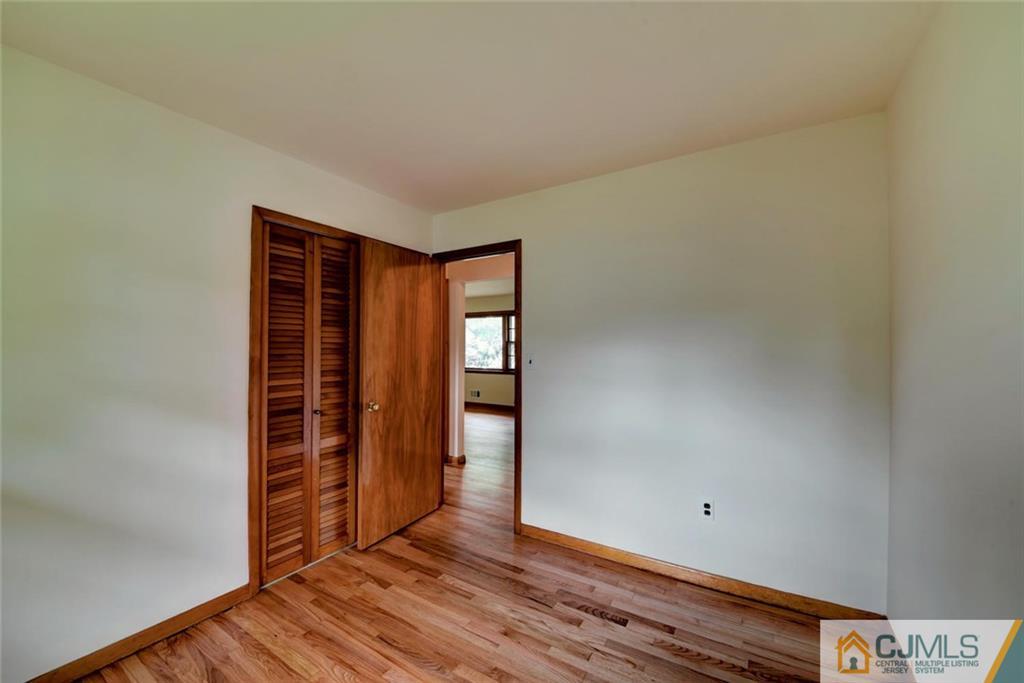 65 Long Hill Road Colonia, NJ 07067 - Photo 11 of 16 an empty room with wooden floor and closet