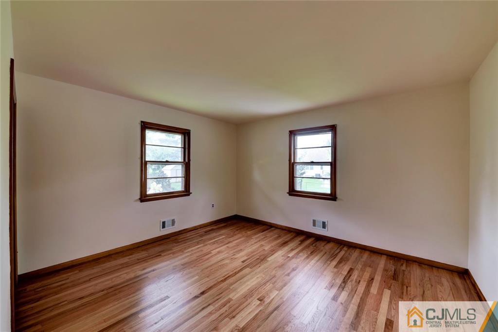 65 Long Hill Road Colonia, NJ 07067 - Photo 12 of 16 a view of an empty room with wooden floor and a window
