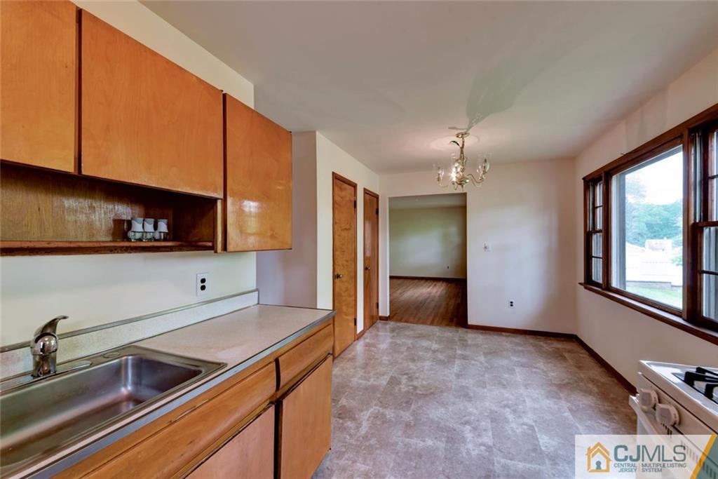 65 Long Hill Road Colonia, NJ 07067 - Photo 7 of 16 a kitchen with stainless steel appliances a sink a stove and a refrigerator