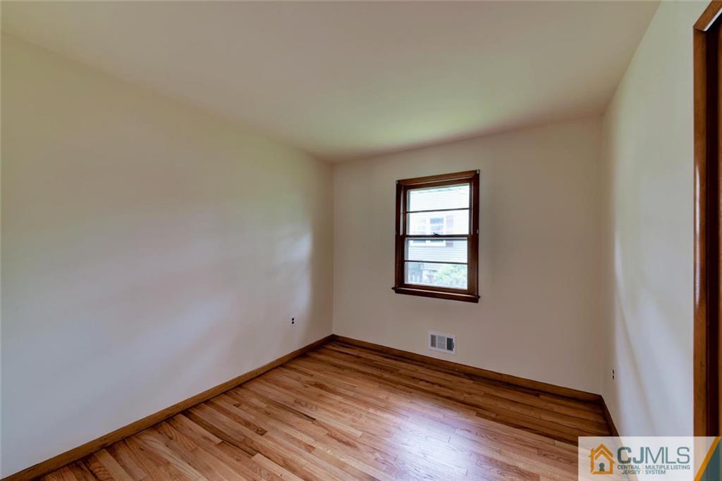 65 Long Hill Road Colonia, NJ 07067 - Photo 10 of 16 a room with a window and wooden floor