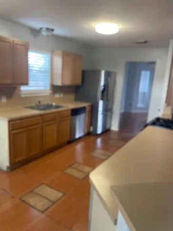 a view of a kitchen with a sink and dishwasher a stove top oven with wooden floor