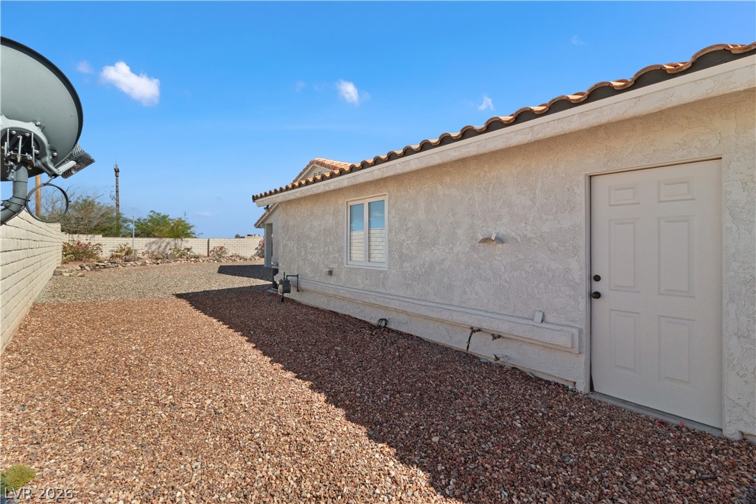 2055 Cholla Way Laughlin, NV 89029 - Photo 61 of 87 A well-maintained side exterior boasts durable stucco and a classic tile roof, ensuring lasting appeal.