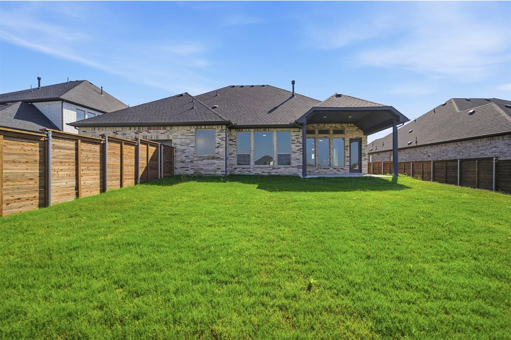2020 Casting Ridge Mesquite, TX 75181 - Photo 34 of 34 Expansive green lawn with a covered patio, full privacy fencing, and a brick and stone exterior
