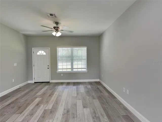 wooden floor in an empty room with a window