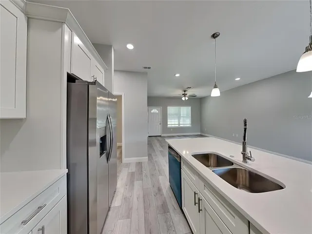 a kitchen with kitchen island white cabinets and refrigerator