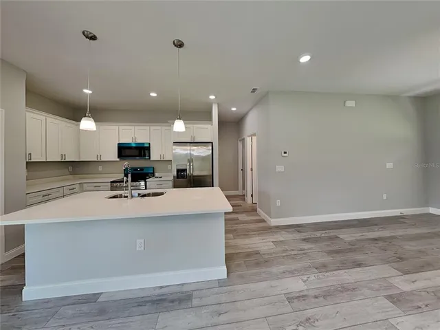 a view of kitchen with stainless steel appliances granite countertop refrigerator sink and stove