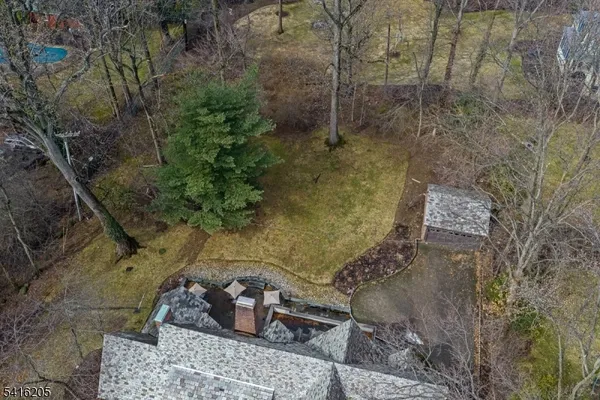 a view of a white house next to a yard with large trees