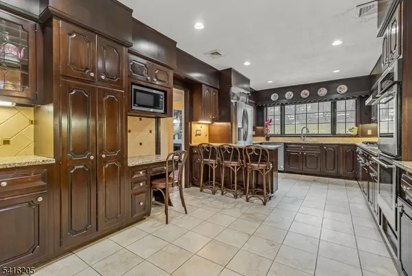 a kitchen with stainless steel appliances granite countertop a refrigerator and a sink
