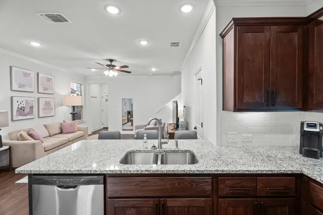 a kitchen with granite countertop a sink and a wooden cabinets