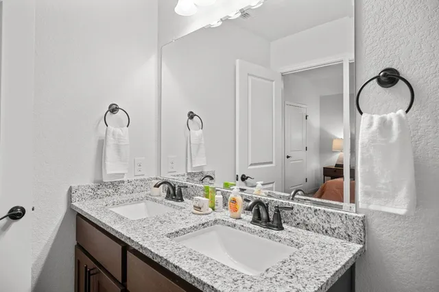 a bathroom with a granite countertop sink and a mirror