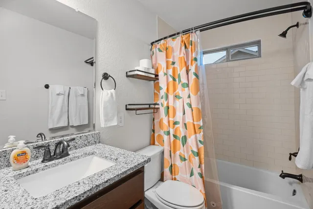 a bathroom with a granite countertop sink toilet and shower